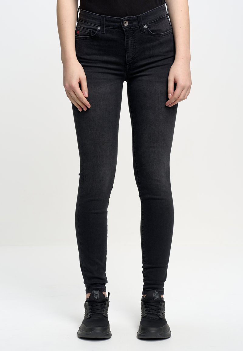 Uske slim-fit crne traperice od denima s glatkom teksturom, koje imaju klasičan dizajn s pet džepova i zatvaranjem na gumb.