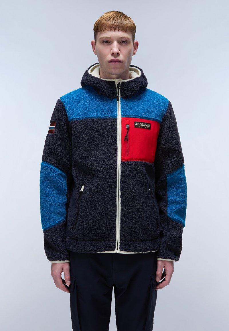 Fleece jacket with a navy body, bright blue and red panels, front zipper, and a hood. Features a pocket on the chest and decorative sleeve patch.
