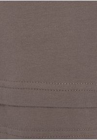 Brauner Baumwollstoff mit glatter Textur, der ein geripptes Strickmuster aufweist und kontrastierende Doppelnähte am Saum hat.