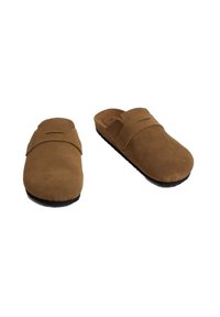 Zoccoli in suede marrone con punta arrotondata e una fascia sopra il collo del piede. Suola in gomma nera testurizzata per la trazione. Design minimalista.