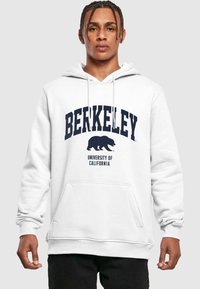 Fehér kapucnis felöltő, elülső kenguru zsebbel. A "BERKELEY" felirat sötétkék ívben, egy medve sziluettjével kiegészítve, alatta "Californiai Egyetem" felirattal.