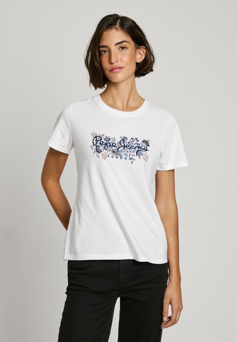 Vit bomull t-shirt med en färgglad blommönster med texten "Pepe Jeans London" i blått. Korta ärmar och rundad hals.