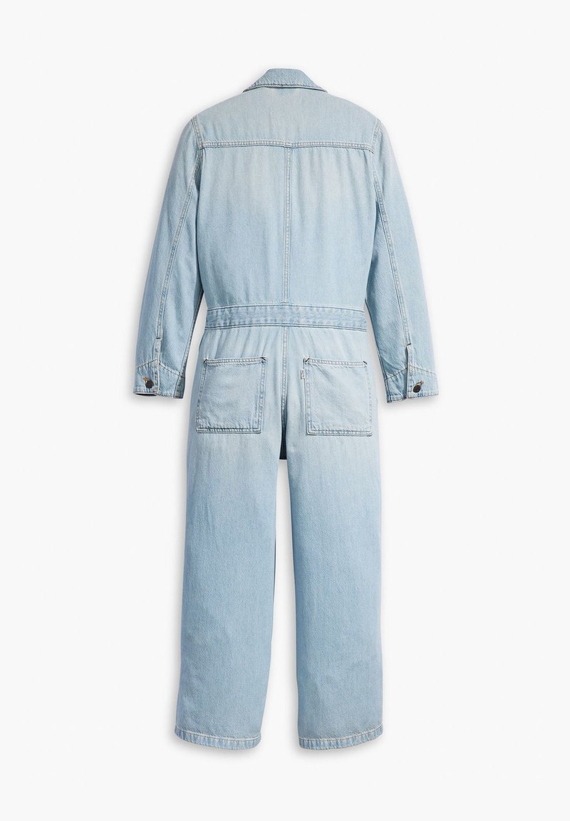 Lyseblå denim-dragtdragt med lange ærmer, forlommer og lige ben. Har krave og knapdetaljer.