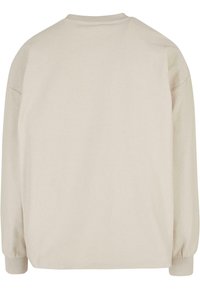 Lichtbeige lange mouw top, met een geribde textuur, ronde halslijn en elastische manchetten, met een ontspannen oversized pasvorm.