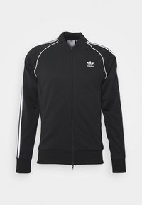 Sudadera tipo track en poliéster negro con franjas blancas a lo largo de las mangas, cierre de cremallera y logo bordado en el área del pecho izquierdo.
