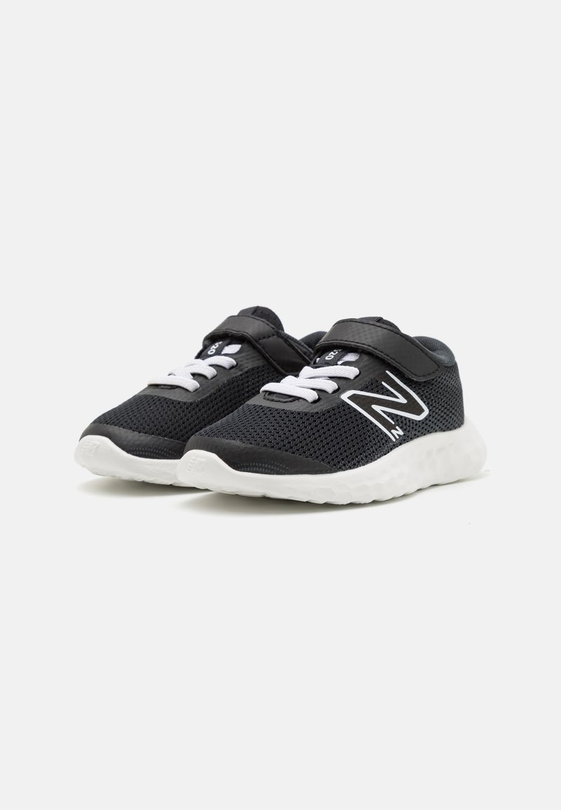 Scarpe sportive in rete nere con dettagli bianchi, dotate di una fascia in velcro e lacci, e una suola bianca imbottita.