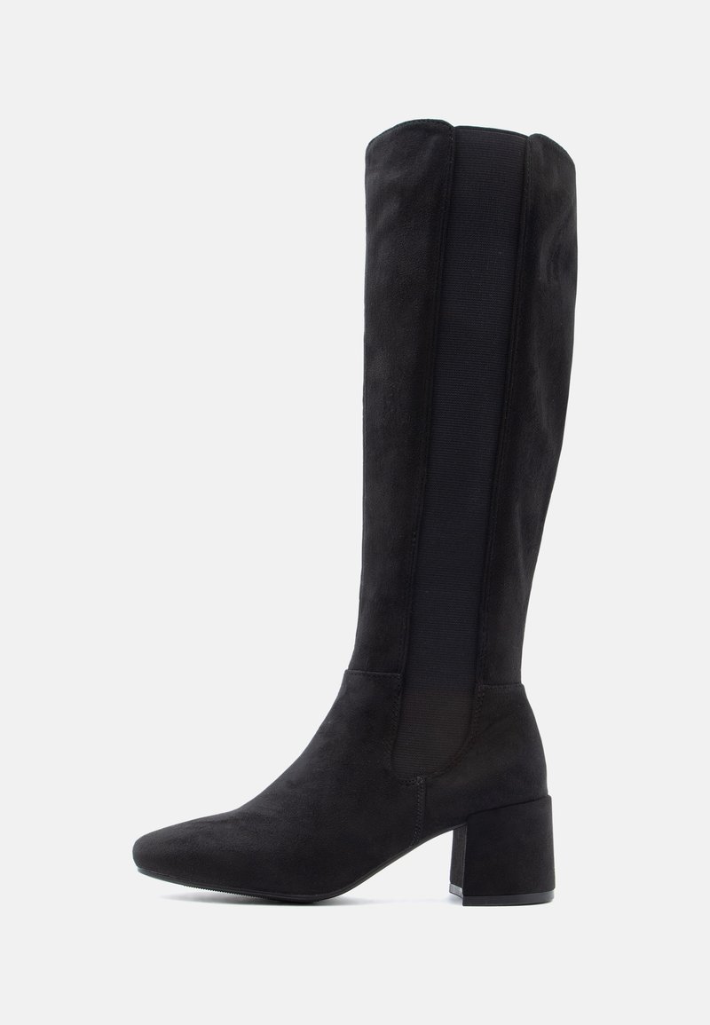 Botte noire en daim montante jusqu'au genou avec talon bloc et panneau latéral élastique sur fond blanc.