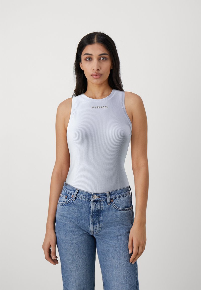 Canottiera a coste blu chiaro con scollatura rotonda, caratterizzata dalla scritta dorata "PINKO". Abbinata a jeans in denim blu chiaro a vita alta.