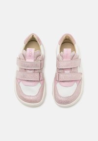 Baskets roses et blanches avec une texture pailletée, deux brides auto-agrippantes et une forme arrondie avec des accents contrastants sur le dessus.