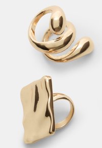 Goldfarbene Metallohrringe mit einem verdrehten Spiraldesign und einem flachen, unregelmäßig geformten Stück, beide mit einer hochglänzenden Oberfläche.