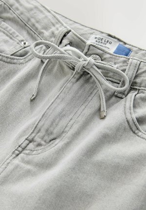 Gray wide-leg trousers made of denim, featuring a drawstring waist, front pockets, and metal hardware details.