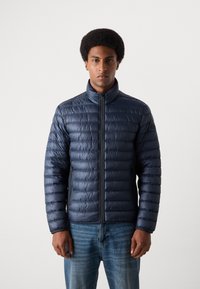 Marineblå dunjakke med horisontalt quiltet design, høy krage, glidelås foran og lommer på siden. Laget av glatt, blankt stoff.