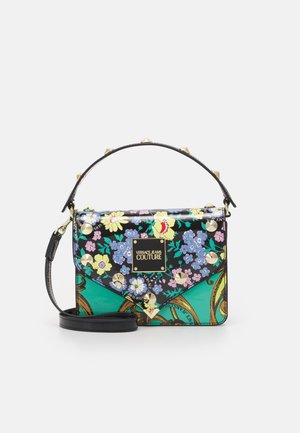 Petit sac à main Versace Jeans Couture avec motif floral et chaîne, clous dorés, poignée noire sur le dessus et bandoulière amovible.