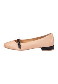 Ballet flats en cuir nude avec un bout carré, des détails en sangle noire, des ferrures argentées et un petit talon noir. Texture lisse, design minimaliste.
