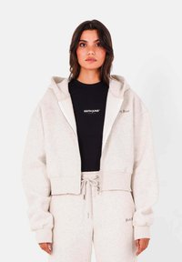 Ljust grå kortärmad hoodie med dragkedja framtill, stor huva och ribbade ärmar, ihopparad med matchande joggers med dragsko i midjan.