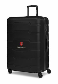 Valise rigide noire avec design texturé, équipée d'une poignée rétractable, de quatre roues et d'un badge logo à l'avant.