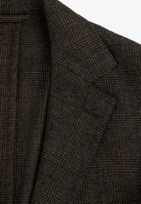 Blazer texturizado marrón con un patrón de pata de gallo y acentos azules. Se pueden ver las solapas clásicas y las costuras detalladas.