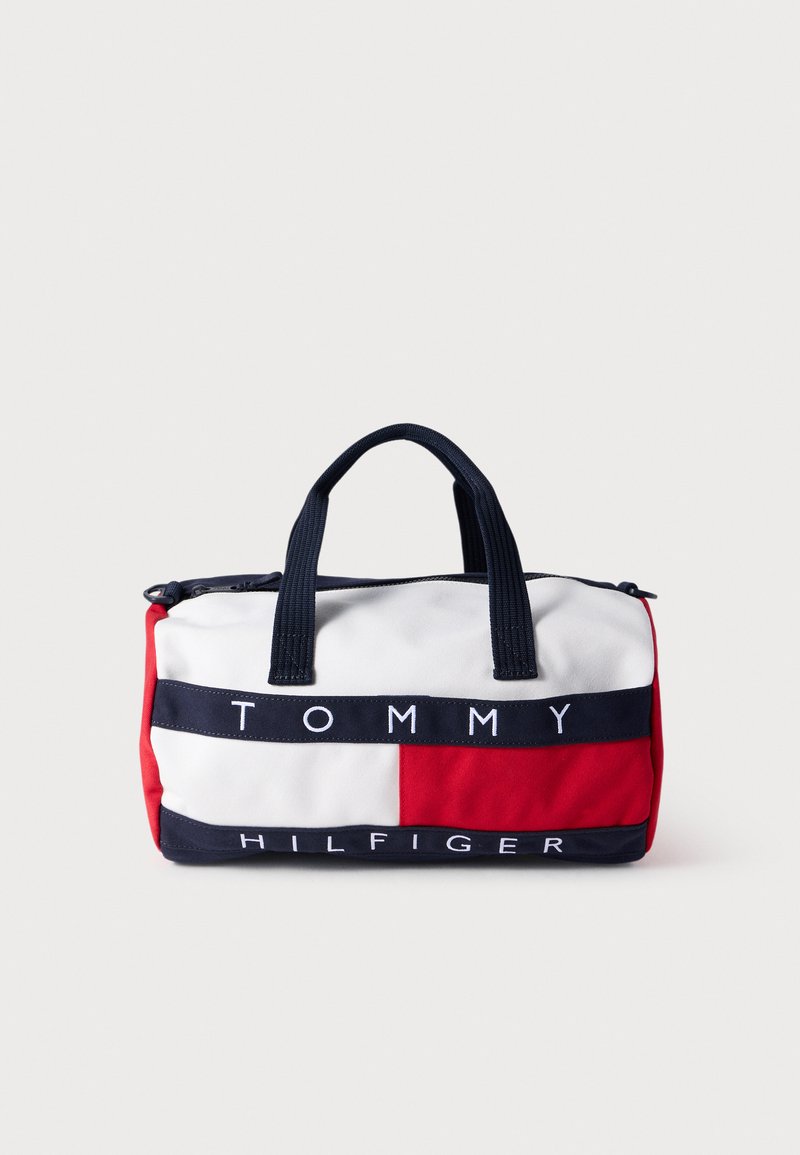 Κόκκινη, λευκή και μπλε τσάντα από καμβά με στρογγυλό σχήμα, διπλές λαβές και κλείσιμο με φερμουάρ. Φέρει την επιγραφή «TOMMY HILFIGER» με έντονα γράμματα στο μπροστινό μέρος.