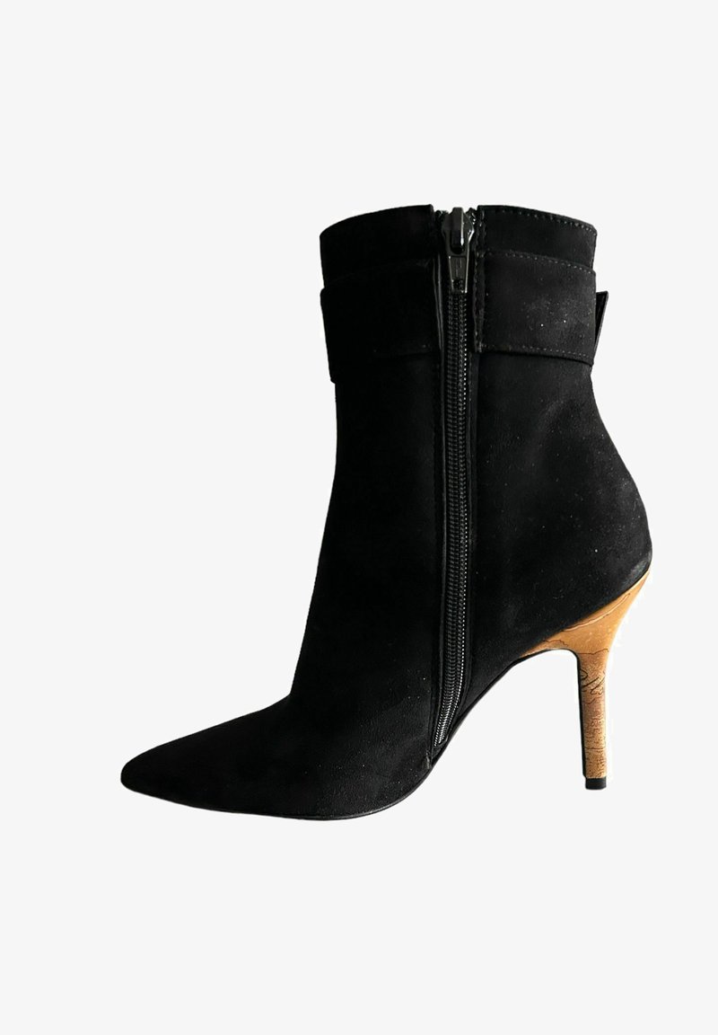 Stivale alla caviglia in suede nero con punta affusolata, cerniera laterale e tacco a stiletto in sughero. Presenta un design a risvolto nella parte superiore.