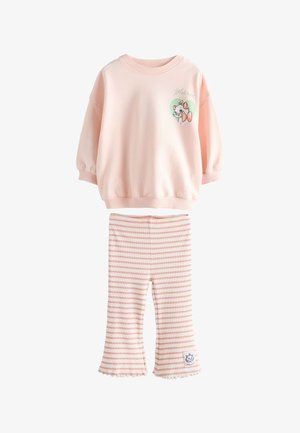 Hellrosa langärmliges Oberteil mit einem Katzenmotiv und rosa-weiß gestreiften ausgestellten Hosen mit Rüschen am Saum und einem Katzenpatch.