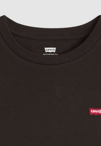 T-shirt in cotone nero con scollatura rotonda e maniche corte. Presenta un piccolo logo Levi's ricamato in rosso sul davanti.