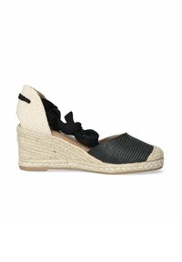 Espadrille a rayas blancas y negras con cuña de yute trenzado, que presenta una parte trasera de lona con un patrón y correas de tela negra para asegurar el pie.