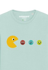 T-shirt en coton bleu clair avec un graphique de Pac-Man jaune et quatre personnages colorés distincts (rouge, bleu clair, vert) avec des expressions variées.