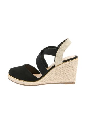 Black wedge sandal with woven beige heel, crisscross elastic straps, and closed toe, angled side view on white background.