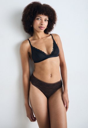 Black lace-trimmed bralette with adjustable straps paired with brown striped high-waisted panties, showcasing soft textures and contrasting patterns.