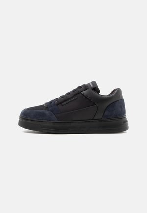 Sneaker nera low-top con dettagli in suede blu scuro, pannelli in mesh e logo del marchio sul lato e sulla linguetta.
