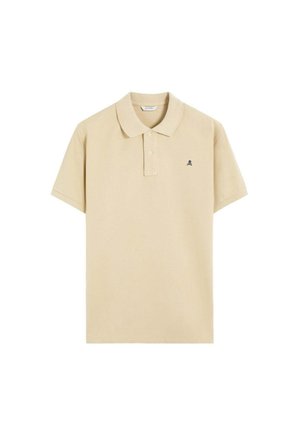 Polo de manga corta beige con cuello, tapeta de dos botones y pequeño logo de calavera negra en el pecho izquierdo.