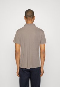 Šedé polo tričko s jemnou texturou, krátkými rukávy a žebrovaným límcem. Tričko má přímý lem a minimalistický design.