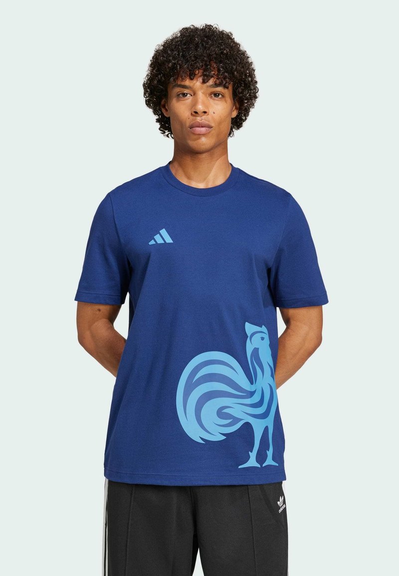 Marineblauwe katoenen T-shirt met een grote lichtblauwe haanafbeelding op de voorkant en drie witte strepen op de linkerschouder.