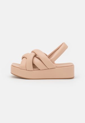 Nagie sandały na platformie z plecionymi paskami, wykonane z miękkiej skóry, z okrągłym czubkiem i gładką teksturą. Posiadają grubą podeszwę dla podwyższenia.