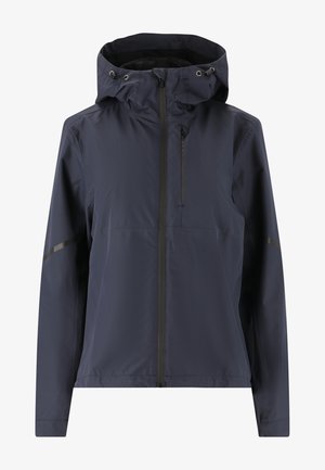 Tummansininen vedenpitävä takki, jossa on säädettävä huppu, etuvetoketju, sivutaskut ja heijastavat yksityiskohdat hihoissa paremman näkyvyyden takaamiseksi.