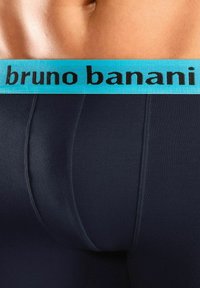 Dark blue cotton boxer briefs with a wide turquoise waistband featuring the text "bruno banani" in black. Smooth texture with a snug fit.