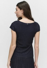 Navy blue, short-sleeved top with a ribbed texture. Features a round neckline and a small, round accent at the back.