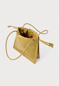 Borsa gialla in pelle con coulisse e texture liscia, con interno rosa. Dotata di una tracolla lunga e sottile e di una base strutturata.