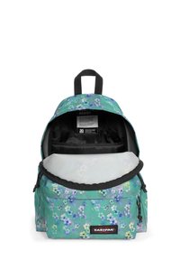 Mochila en azul verdoso con patrón floral. Cuenta con un asa superior, cierre con cremallera, un bolsillo exterior y un interior negro con un compartimento acolchado.