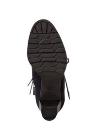 Botas de ante azul oscuro con una suela de goma negra texturizada que presenta un patrón de pisada distintivo y elementos decorativos de cordones en los laterales.