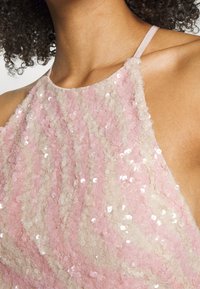 Vestido sem mangas em rosa e creme com lantejoulas texturizadas em padrões espiralados, apresentando um decote arredondado e alças finas.