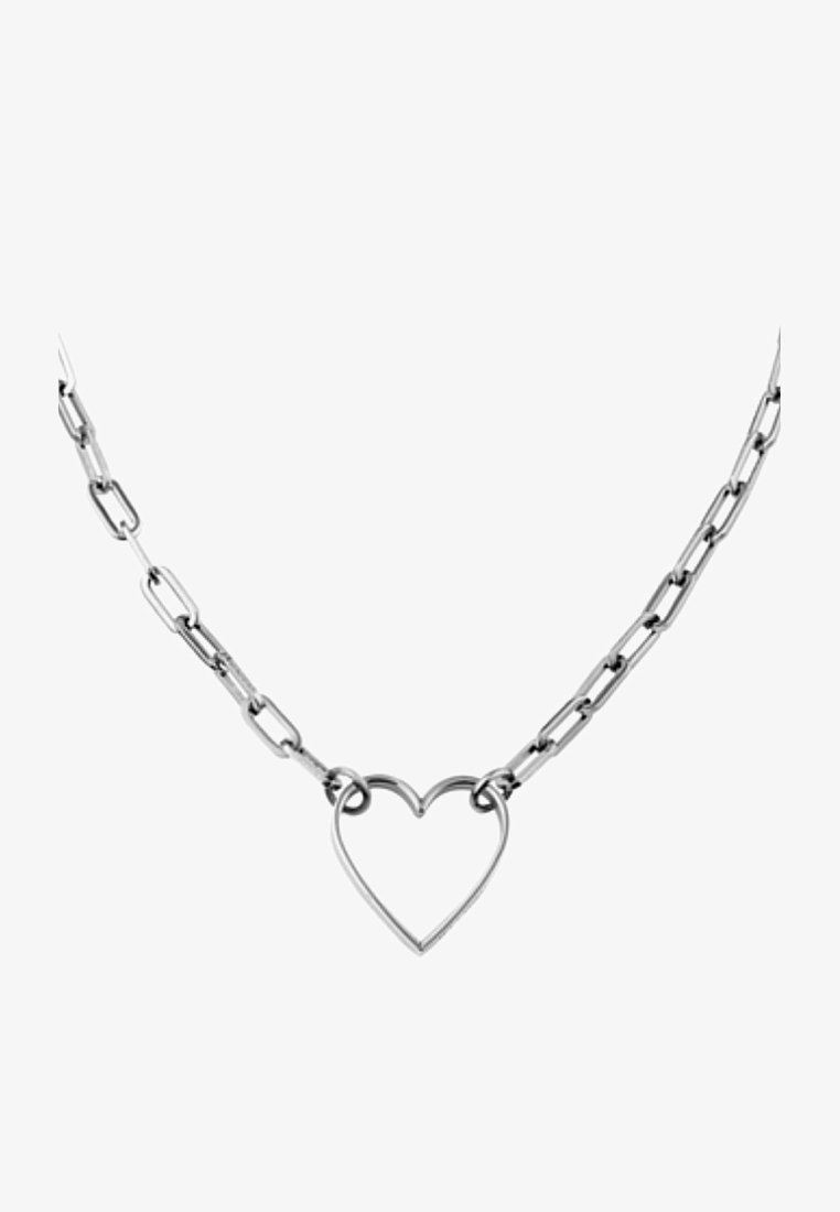 Collier chaîne en argent avec un pendentif creux en forme de cœur au centre sur fond blanc.
