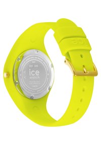 Reloj de silicona amarillo brillante con una parte trasera redonda de metal plateado, hebilla en tono dorado y textura suave; cuenta con resistencia al agua de hasta 10 ATM.