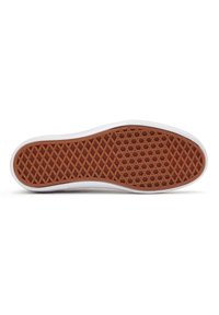 Semelle de chaussure de sport blanche avec un design en caoutchouc texturé. Présente un motif alvéolaire marron, avec un bord lisse faisant la transition vers la tige.
