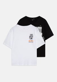 Dos camisetas de manga corta: una blanca con un gráfico de un tigre y texto, la otra negra con letras verdes. Ambas son de algodón y de cuello redondo.