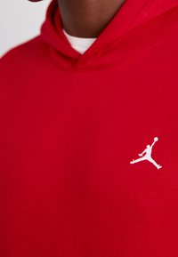 Felpa rossa con cappuccio realizzata in cotone, con una tasca frontale e un accento del logo Jumpman bianco sul petto. Design semplice e casual con cappuccio.