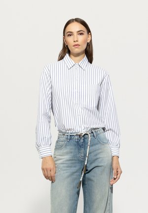 Weißes Hemd mit knöpfen, mit navyblauen vertikalen Streifen, langen Ärmeln und einer Brusttasche, kombiniert mit hellblauen, distressed Jeans und einem gemusterten Gürtel.