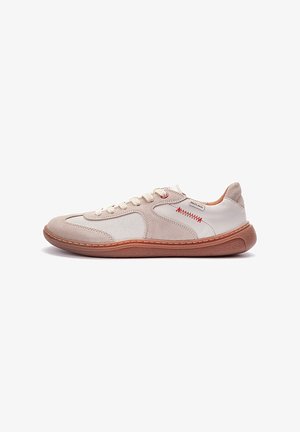 Zapatillas con parte superior de ante beige y malla blanca, puntera redonda, cierre de cordones y costuras rojas contrastantes en el lateral. Suela de goma marrón.