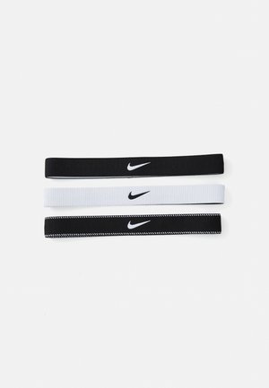 Três faixas de cabelo Nike: uma preta sólida, uma branca sólida e uma preta com costura branca, todas com um pequeno logotipo da Nike em branco.