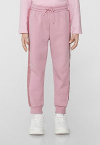 Rosa Jogginghose mit Kordelzugbund, verziert mit glitzernden Seitenstreifen und gerippten Knöcheln. Hergestellt aus weichem, strukturiertem Stoff.